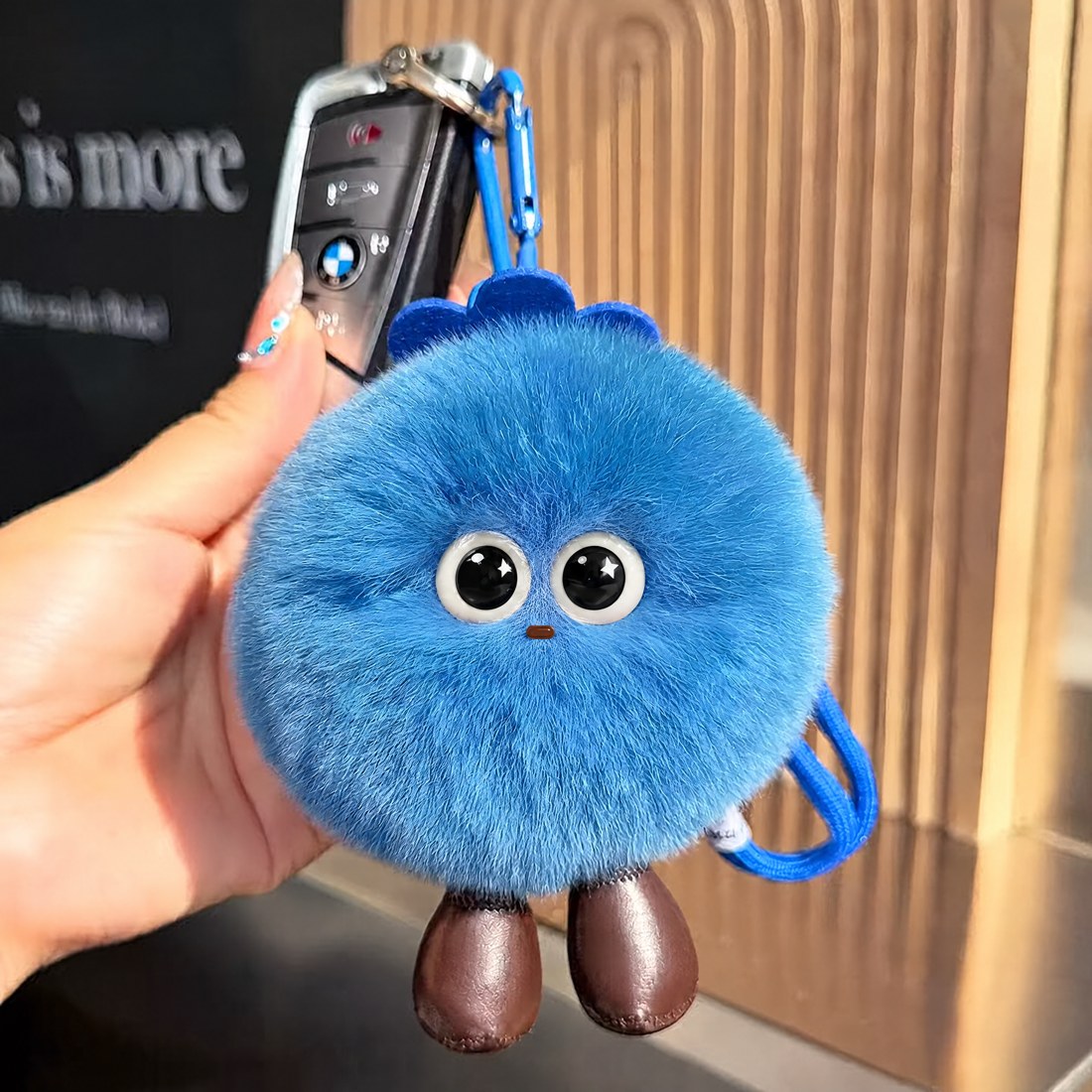 Blue furry round charm with little brown feet